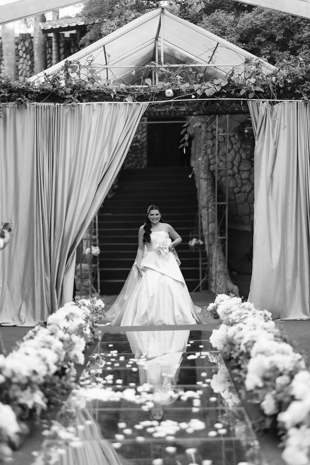 Noiva na entrada do salão espelhado, em preto e branco