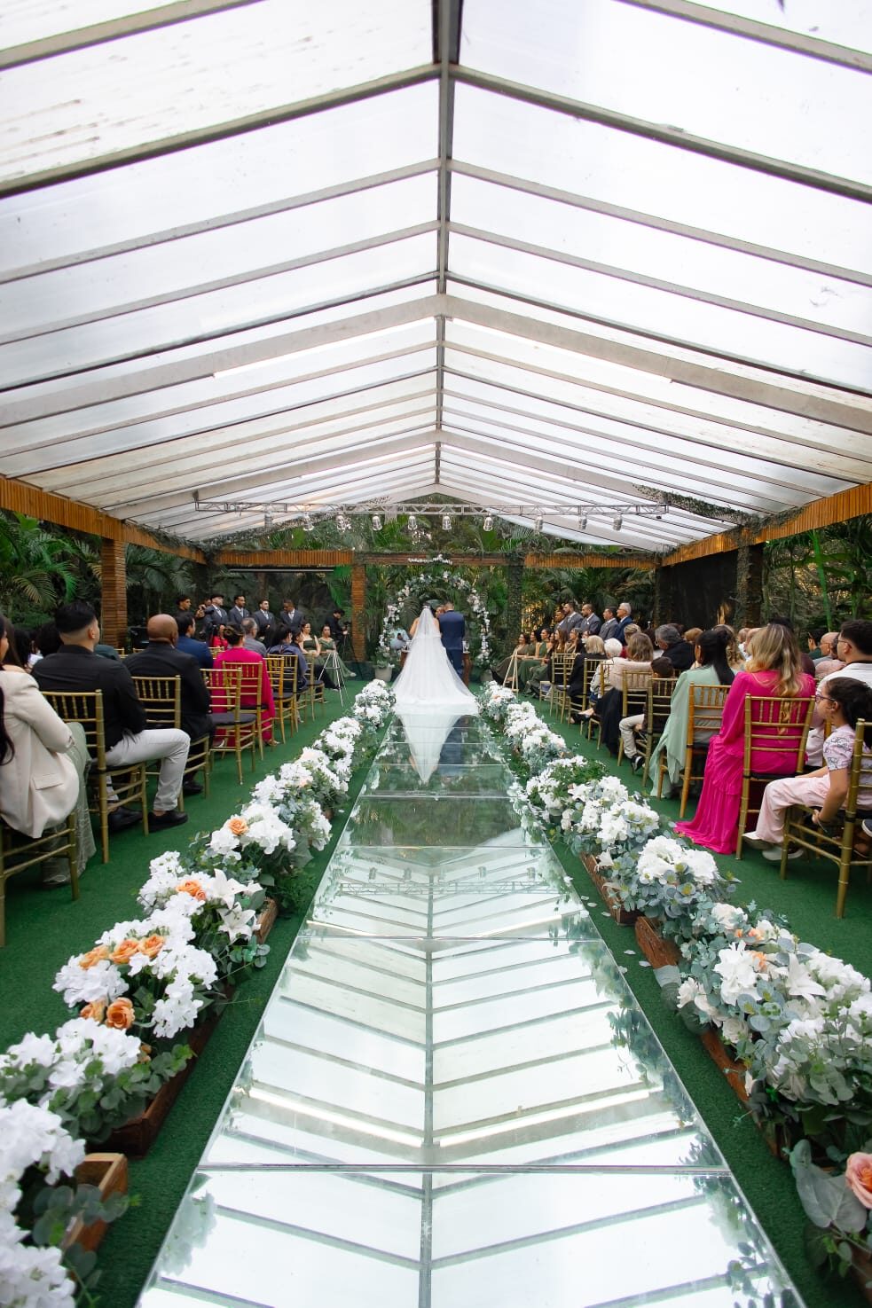 Cerimônia de casamento no Buffet RCK, corredor com piso espelhado e arranjos florais